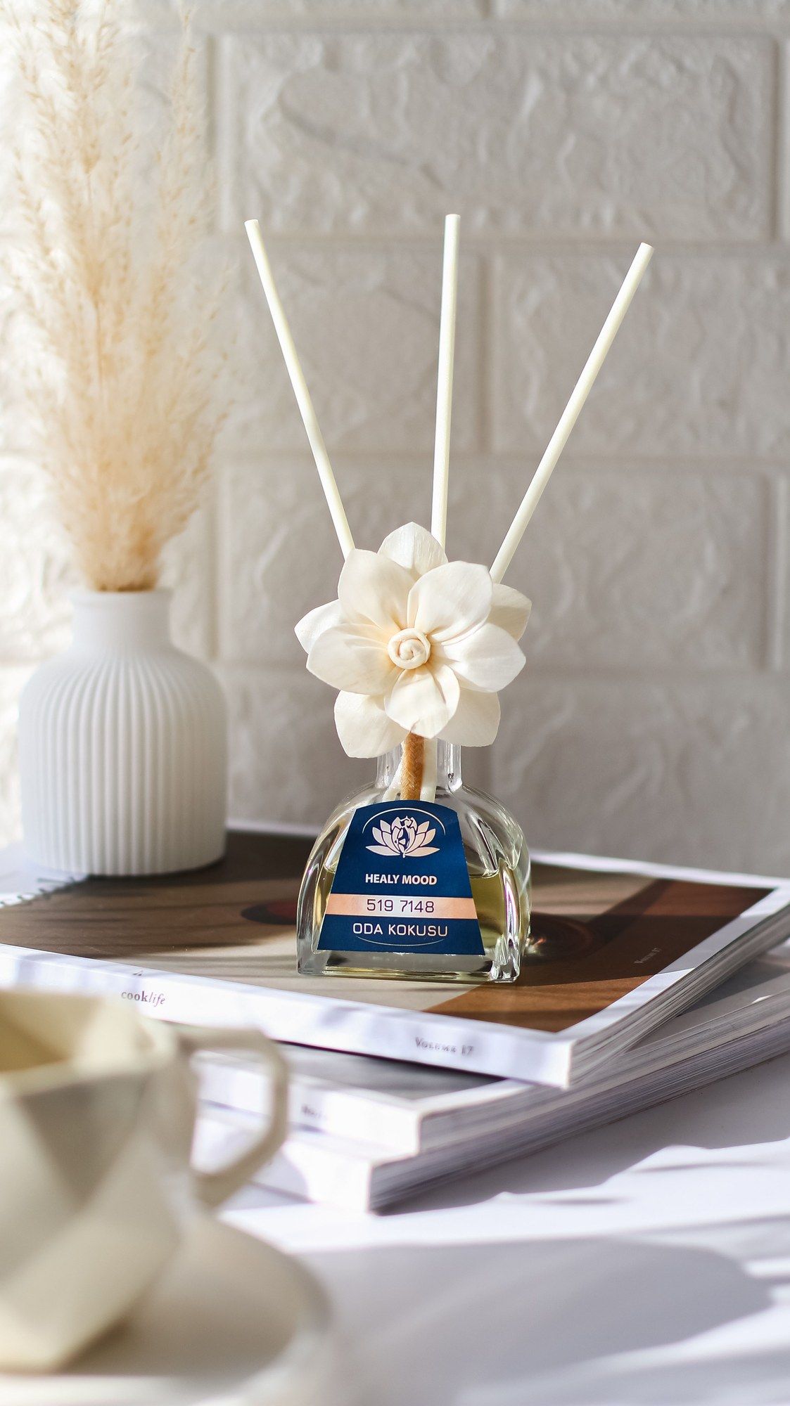 Difusor de varillas con detalle floral sobre una mesa